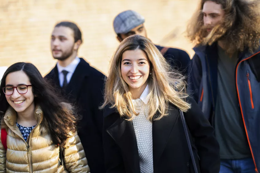 Five students walking outdoors